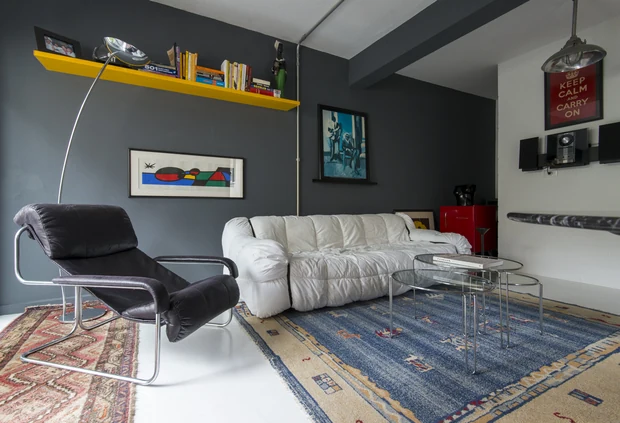 Sala de estar com poltrona de couro e tapetes sobrepostos