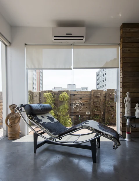 Varanda com chaise longue voltada para o jardim vertical
