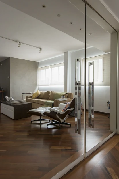Sala de estar com piso de madeira e poltrona Eames